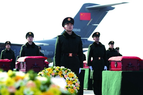 礼兵将殓放志愿军烈士遗骸的棺椁从专机上护送至棺椁摆放区 新华社发